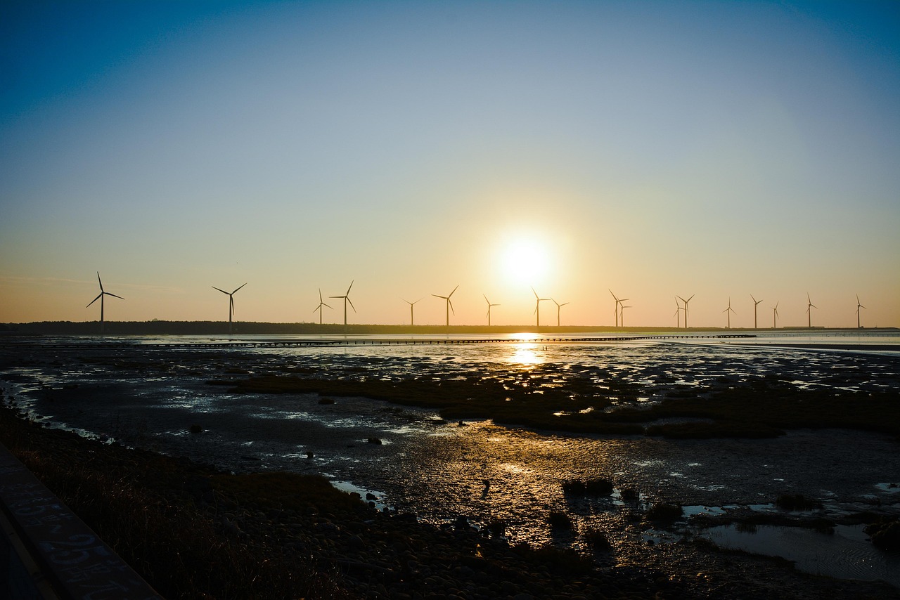 Windmill silhouetted against a golden sunset sky in Taiwan at dusk